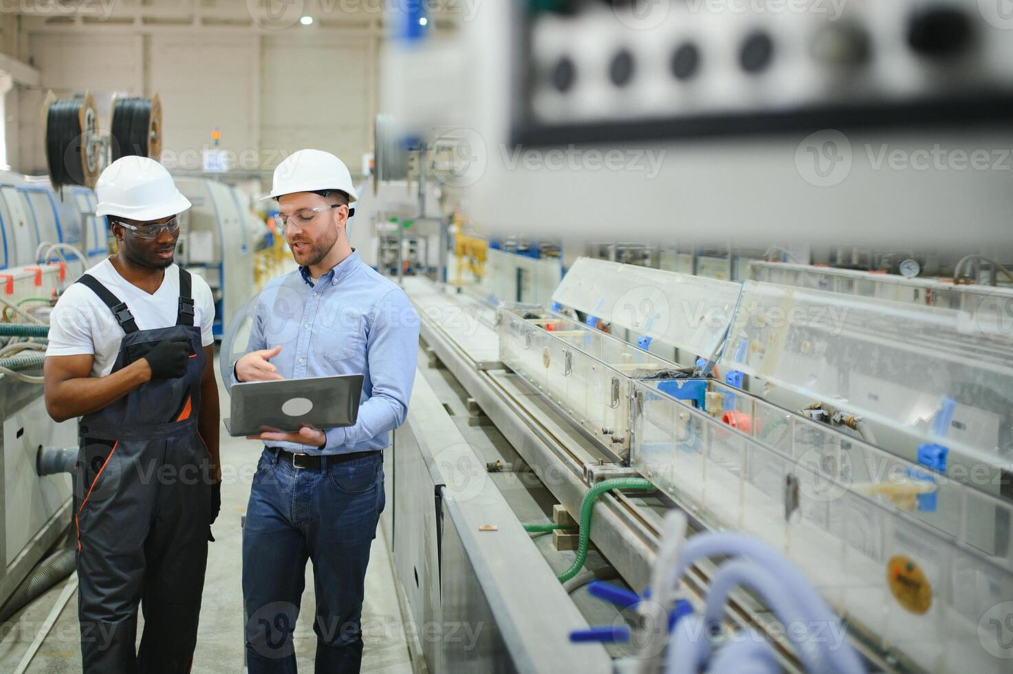 un ingegnere comunica con un' lavoratore su un' produzione linea foto