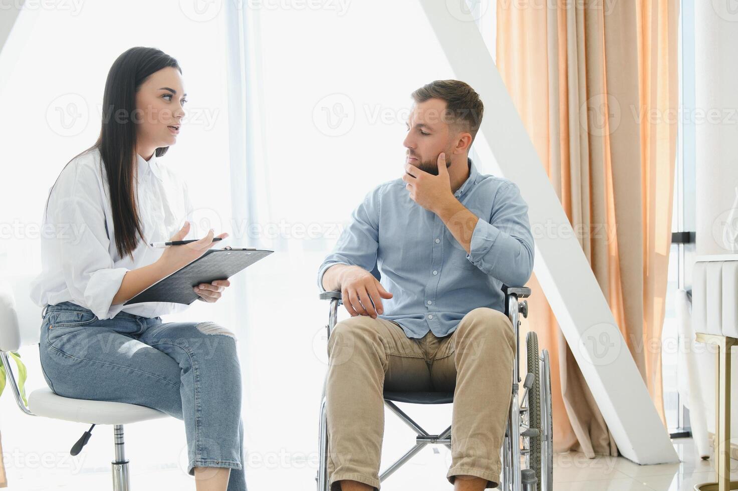 giovane Disabilitato uomo parlando per femmina psicologo a casa foto