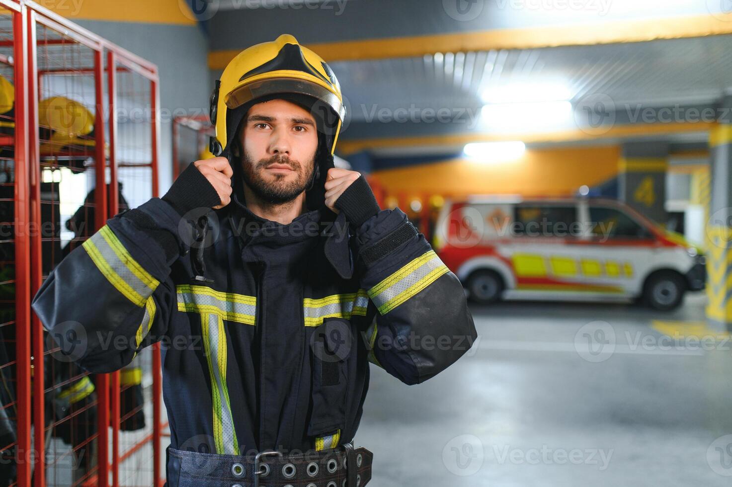 vigile del fuoco indossare protettivo uniforme in piedi nel fuoco Dipartimento a fuoco stazione foto