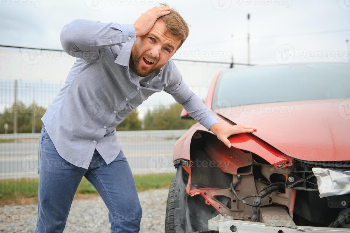 un' frustrato uomo vicino un' rotto macchina. afferrato mio testa rendersene conto il danno è serio, il auto è al di là riparazione foto