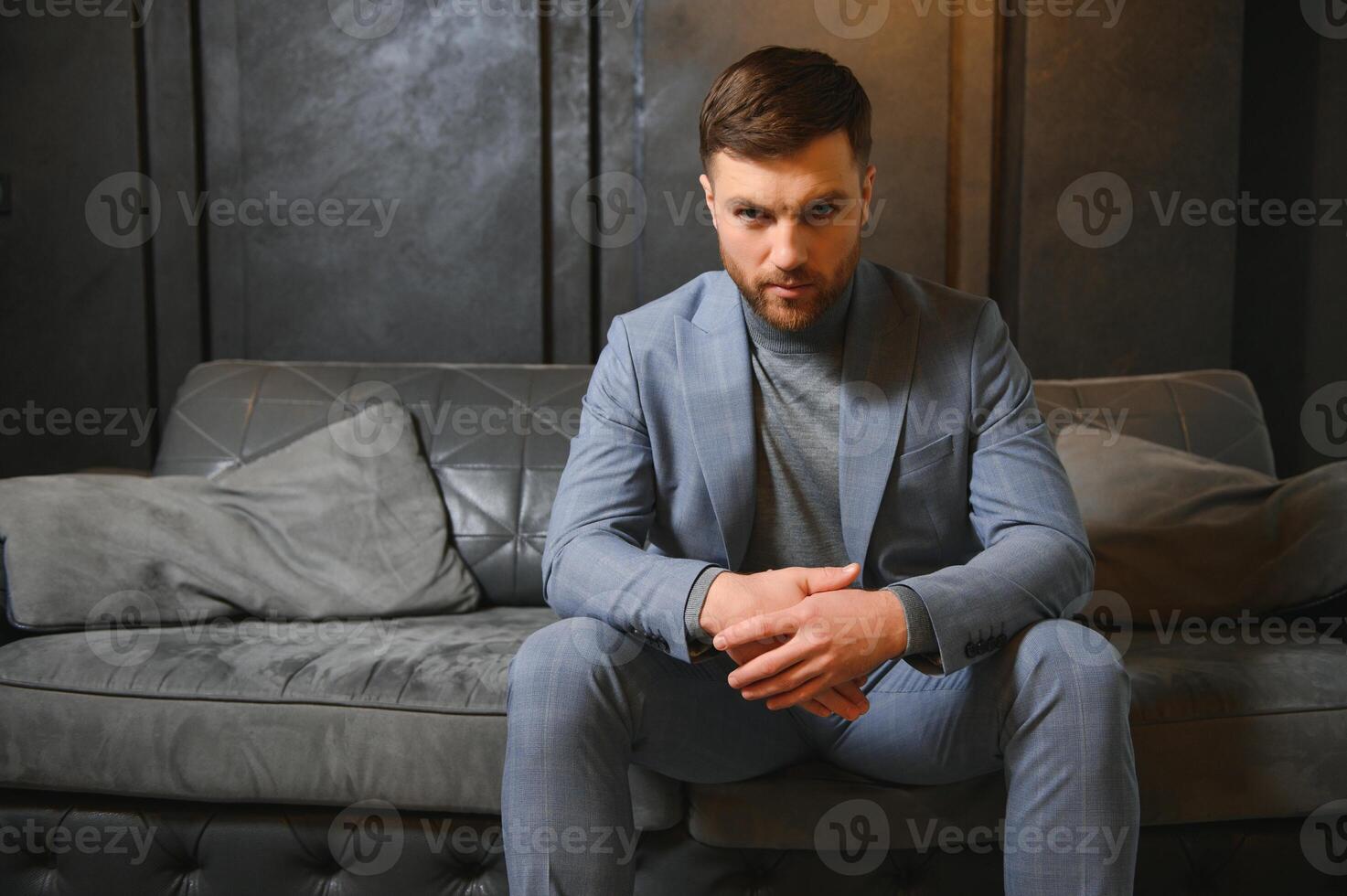 ritratto di un' bello uomo nel un elegante completo da uomo su un' grunge sfondo foto