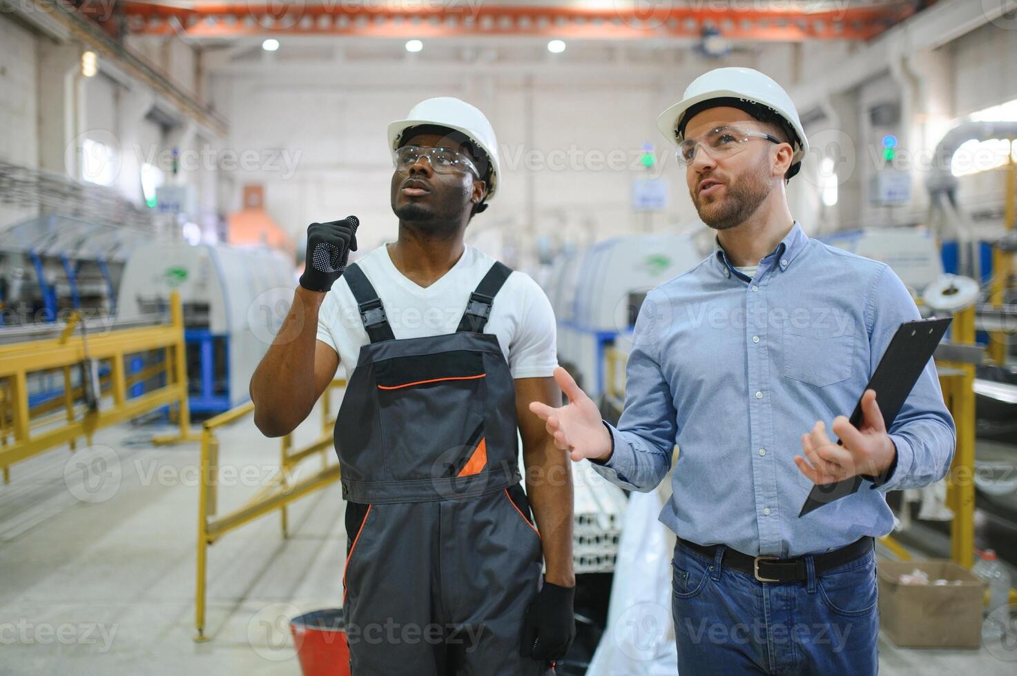 Due lavoratori a il fabbrica. ingegnere e lavoratore foto