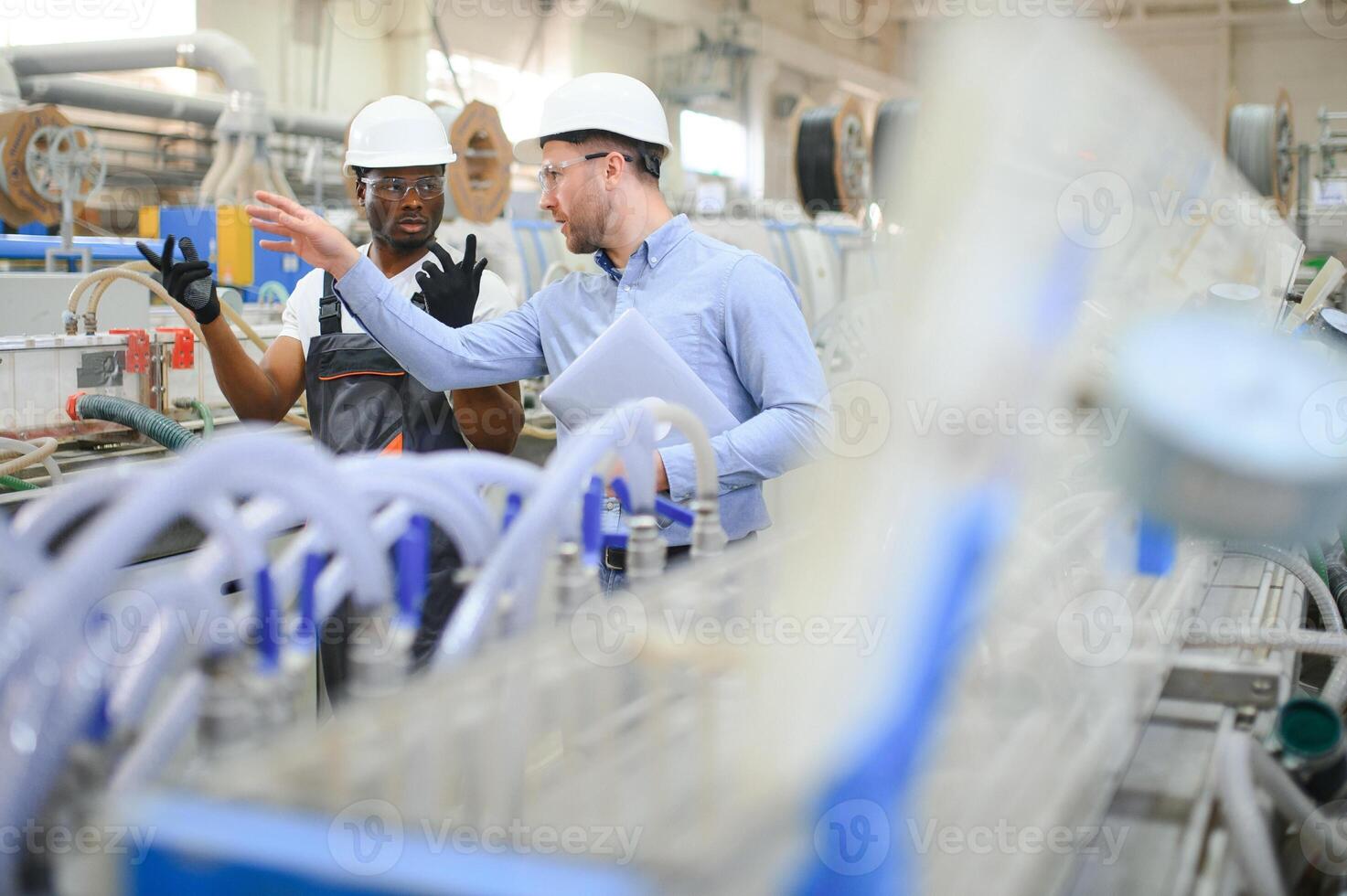 un ingegnere comunica con un' lavoratore su un' produzione linea foto