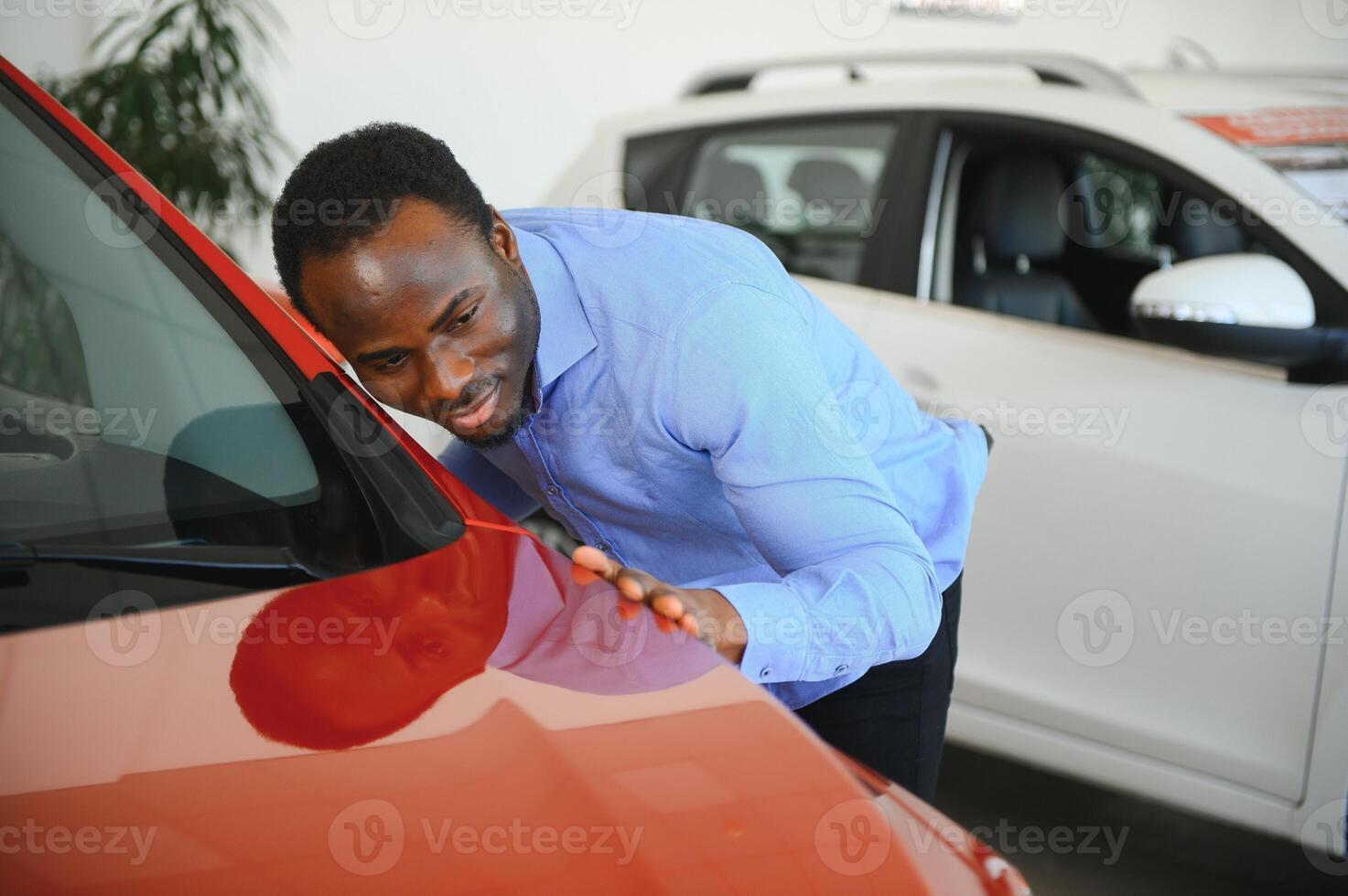 giovane afroamericano uomo è venuto per vedere automobili nel concessionaria o macchine showroom foto
