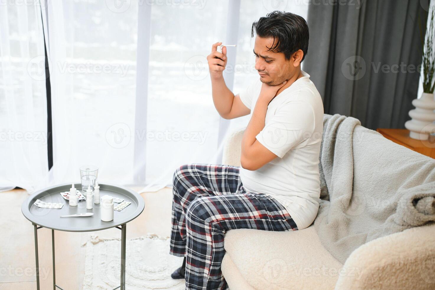 un indiano uomo ha il influenza. un' uomo usi un' gola spray. foto