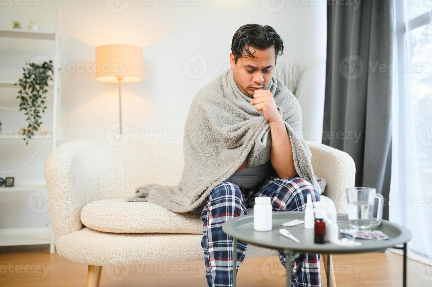 malato indiano uomo nel plaid sedersi solo tremante a partire dal freddo. malsano arabo tipo sedersi su sedia sensazione disagio provare per riscaldamento su foto