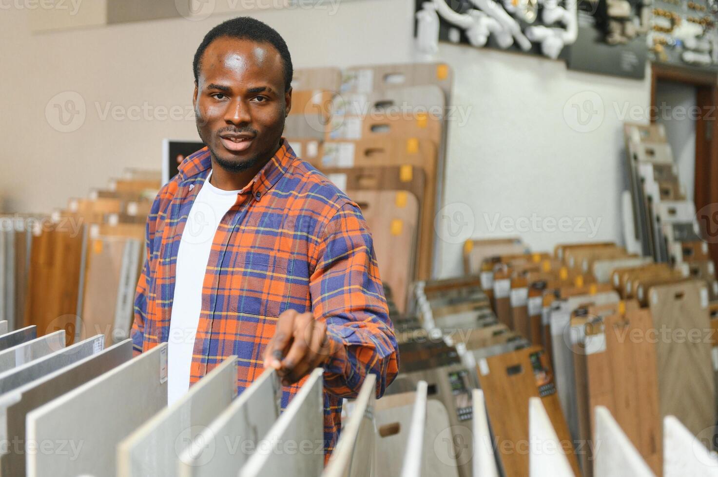 africano americano uomo la scelta piastrelle a edificio mercato foto