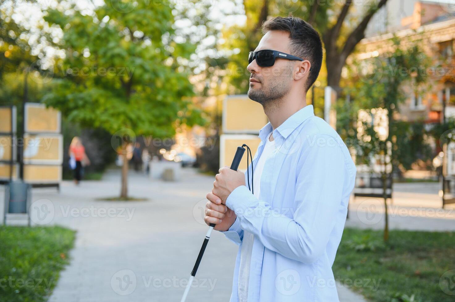 cieco uomo. visivamente alterata uomo con a piedi bastone, foto