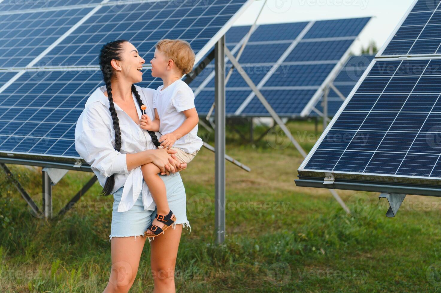 contento madre e sua poco figlio siamo a piedi vicino il solare pannelli. il concetto di verde energia. foto