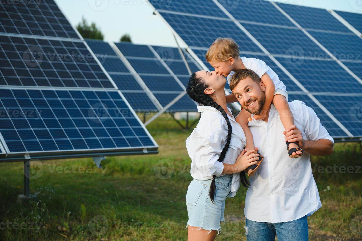 giovane famiglia di tre è accovacciato vicino fotovoltaico solare pannello, poco ragazzo e genitori. moderno famiglia concetto. il concetto di verde energia foto