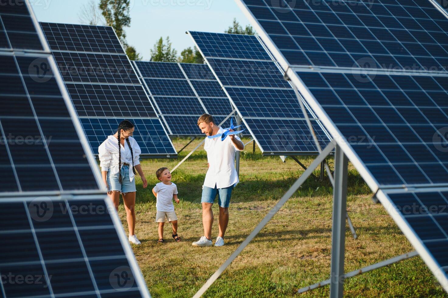 contento famiglia vicino solare pannelli. alternativa energia fonte foto