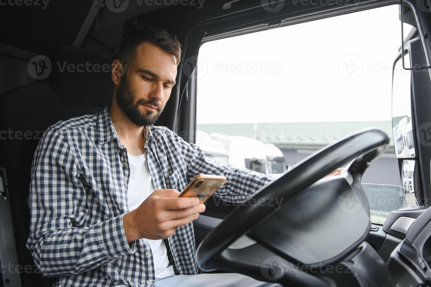 giovane professionale autista comunicare al di sopra di mobile Telefono mentre guida un' camion foto