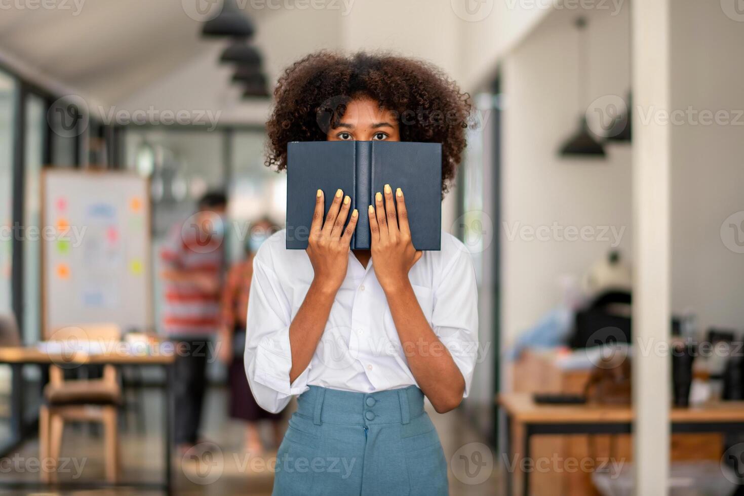 donna nascondere sua viso e occhi schioccato su un' libro foto