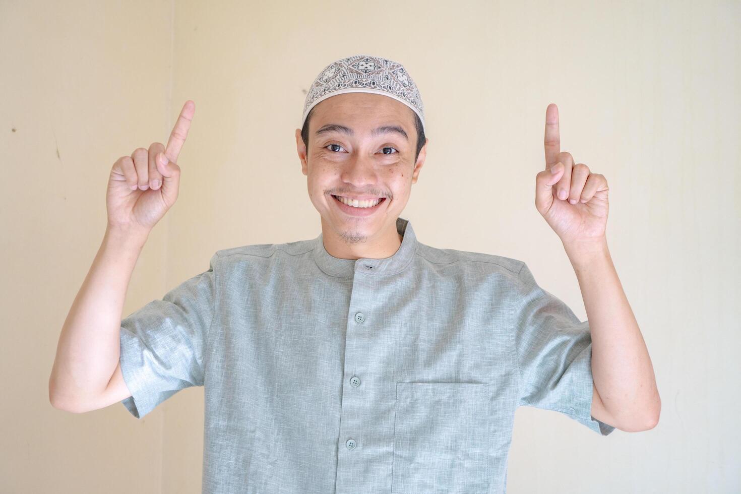 musulmano asiatico uomo puntamento il collegamento gesto quando Ramadan celebrazione. il foto è adatto per uso per Ramadhan manifesto e musulmano soddisfare media.