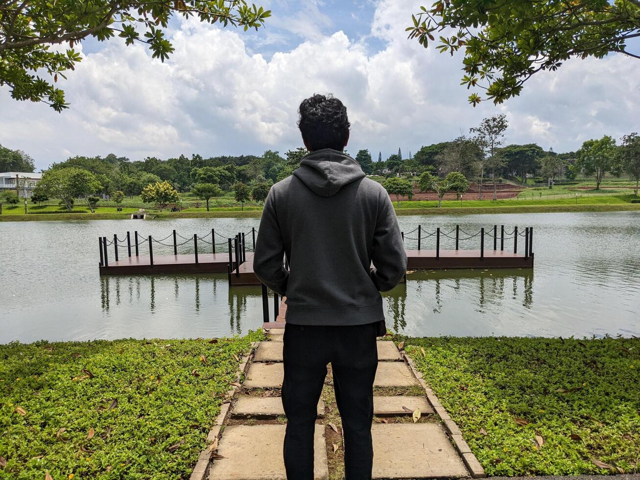 uomo In piedi nel davanti di il modo lago su giù cittadina. il foto è adatto per uso per avventura soddisfare media, natura manifesto e foresta sfondo.