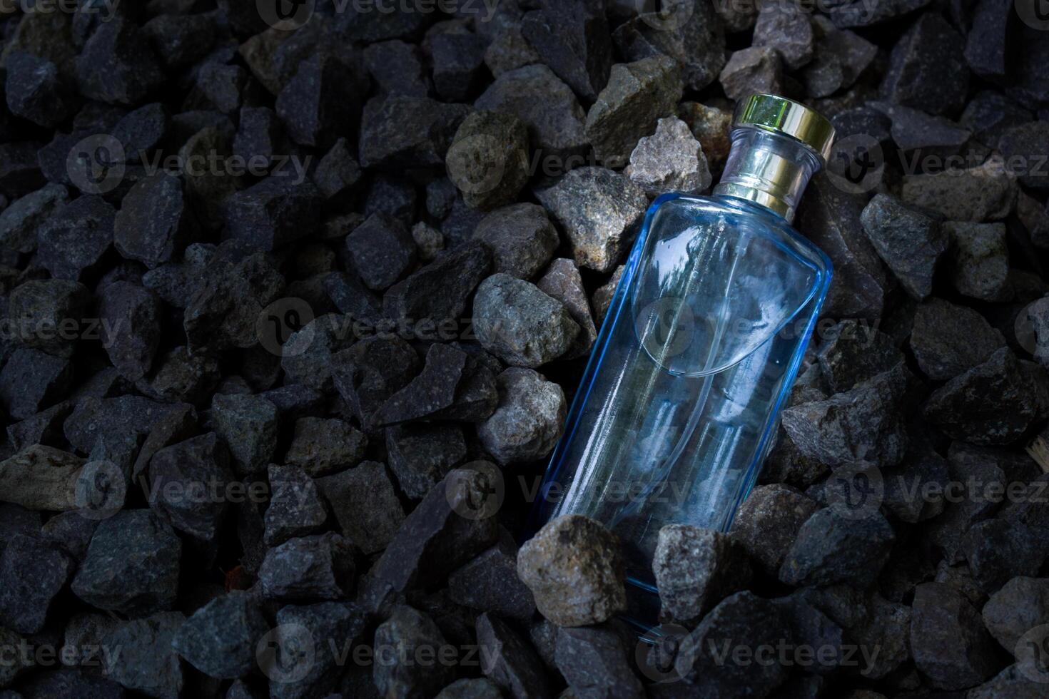 profumo blu trasparente bottiglia nel ghiaia o corallo sfondo foto