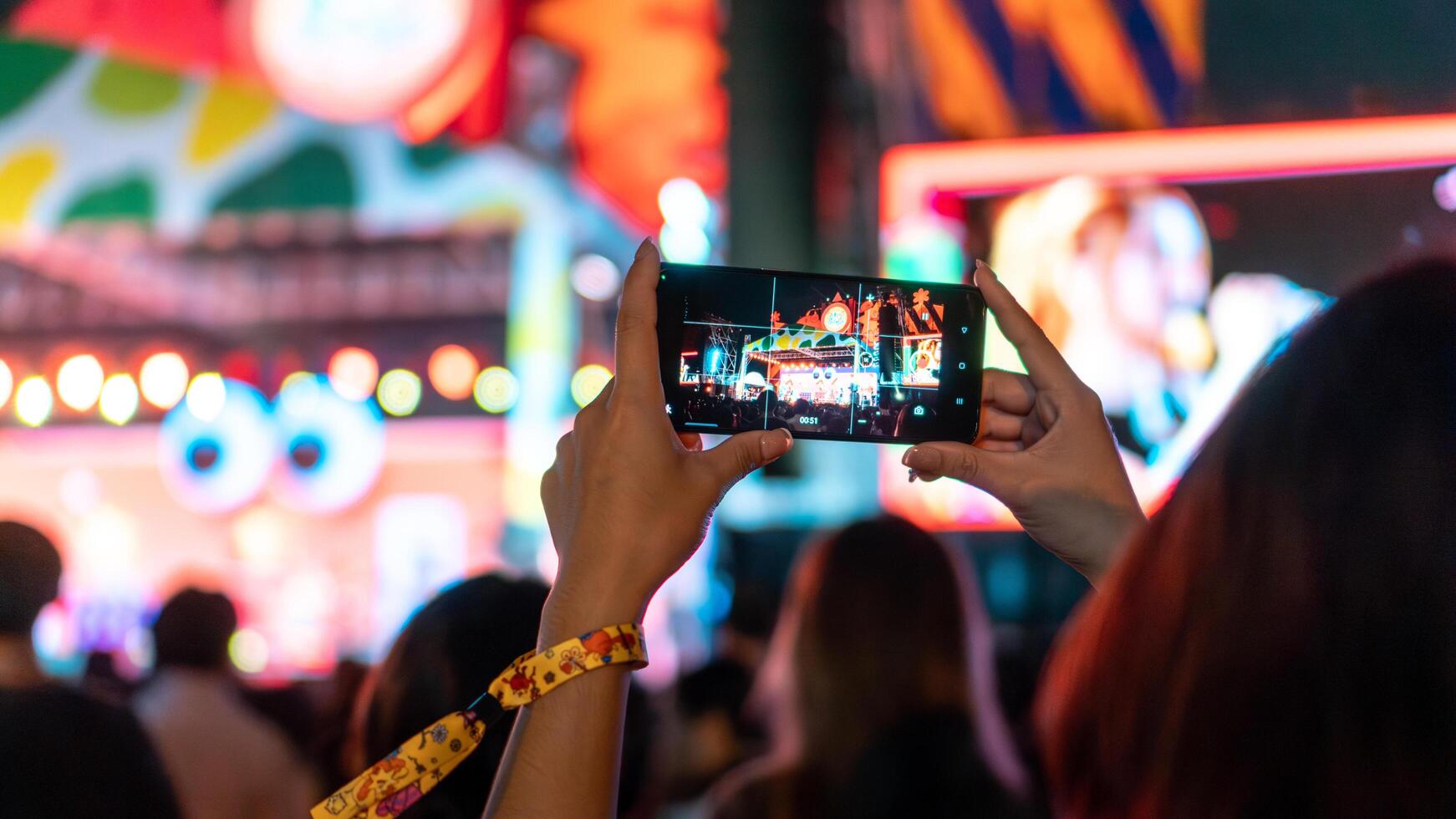 persone Tenere inteligente Telefono e registrazione e Fotografare nel musica Festival concerto foto