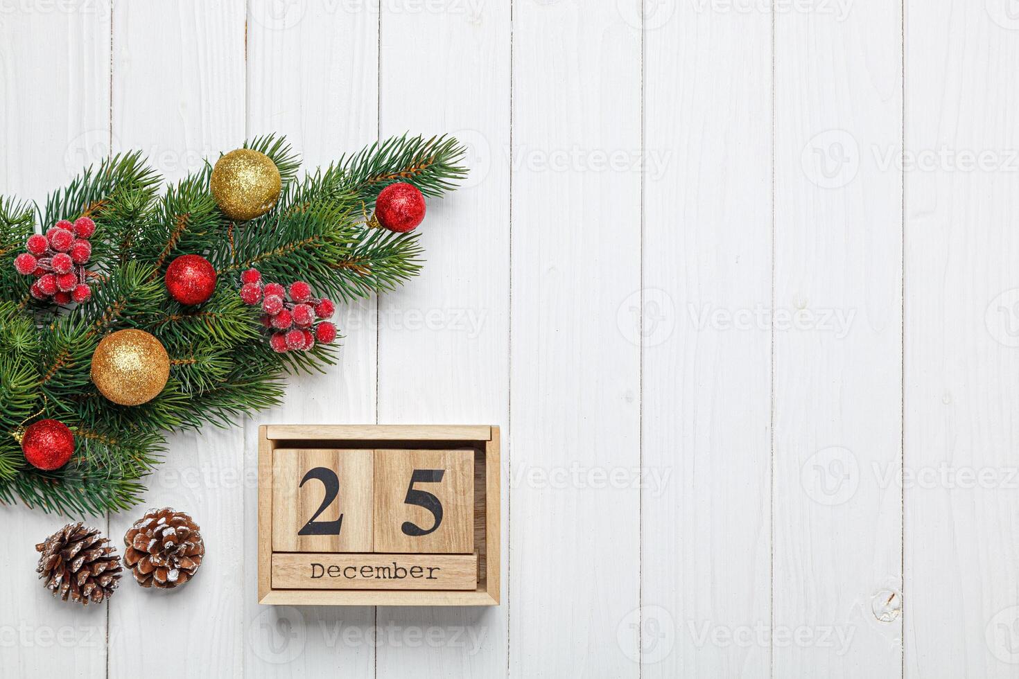 Natale albero ramo con giocattoli e i regali e di legno calendario dicembre 25 su di legno sfondo foto