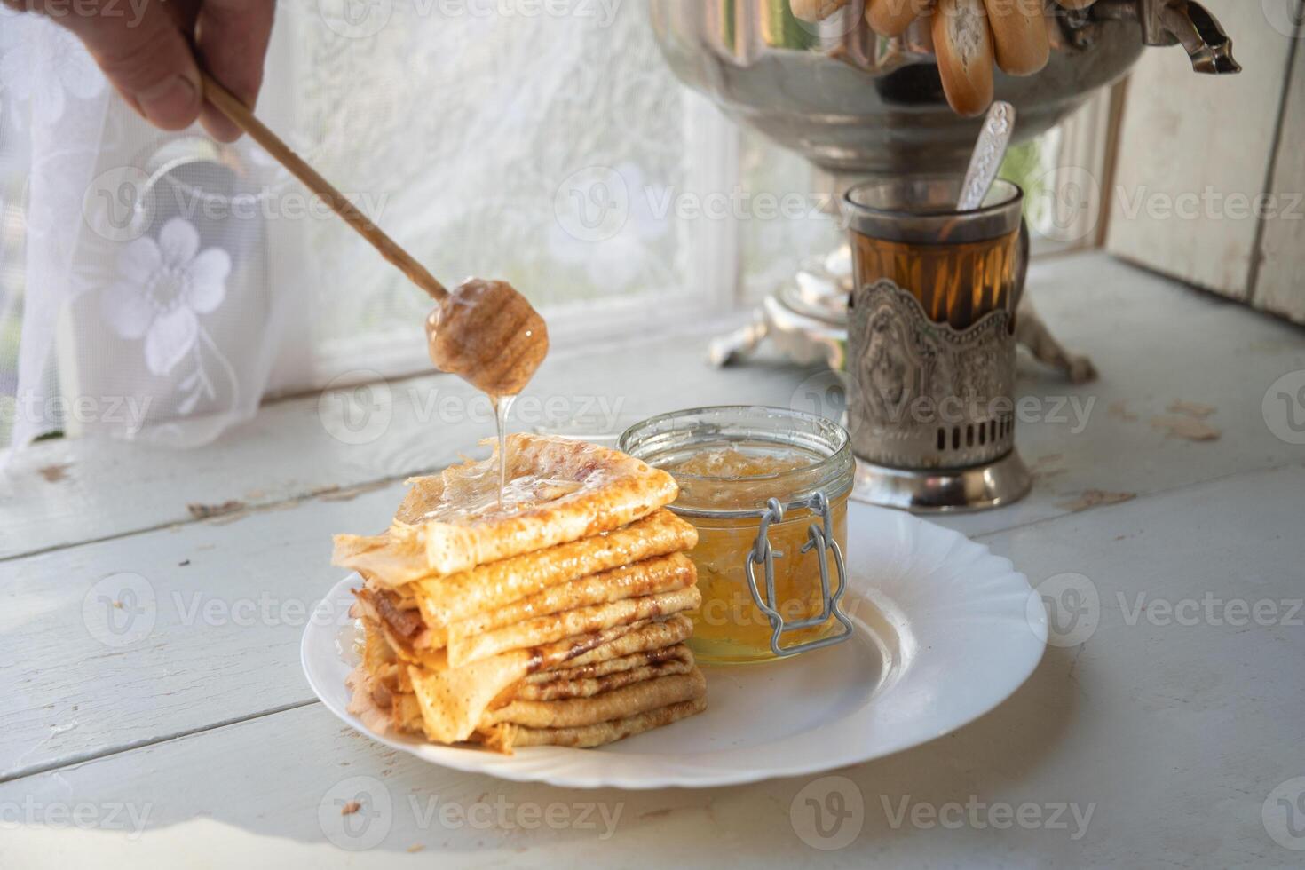 russo Pancakes con miele e un' tazza di tè a partire dal un' Vintage ▾ samovar maslenitsa Festival concetto foto