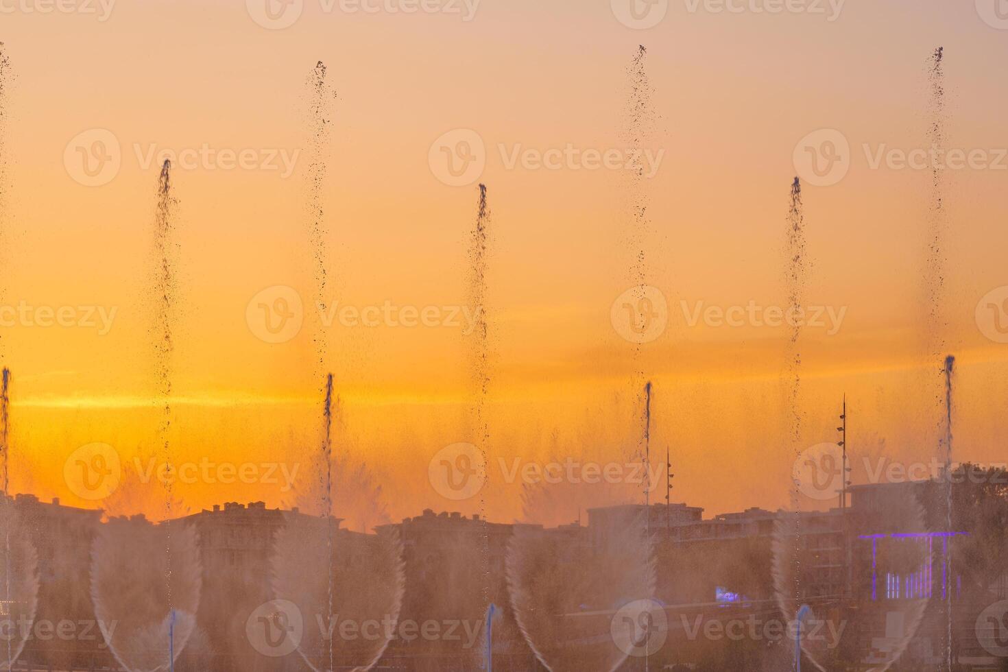 grande fontane su il artificiale stagno, illuminato di luce del sole a tramonto nel compito città parco a estate. foto