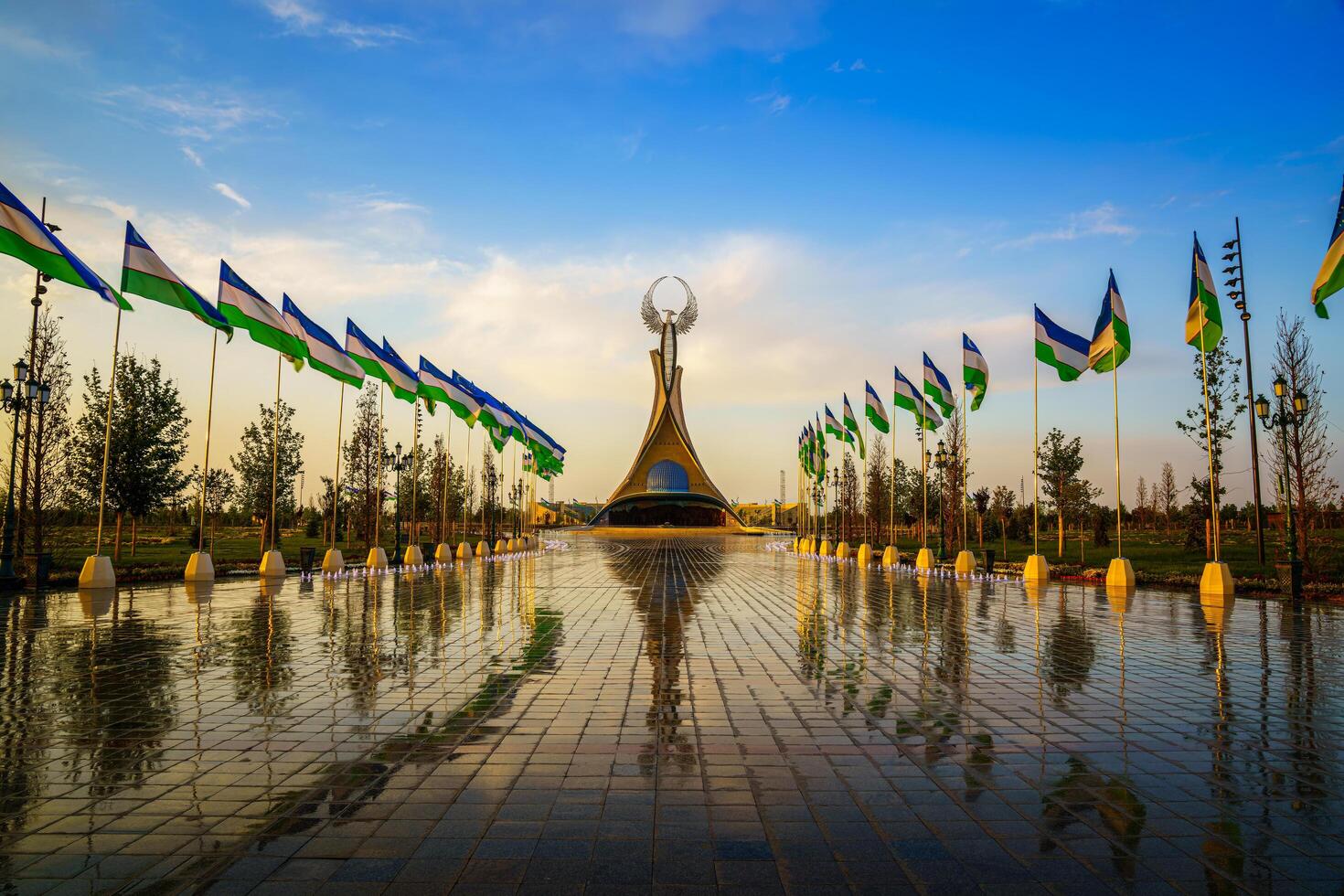 Uzbekistan, compito - Maggio 5, 2023 fontane nel un' sfondo di monumento di indipendenza nel il modulo di un' stele con un' humo uccello e agitando bandiere su un' tramonto dopo pioggia nel il nuovo Uzbekistan parco. foto