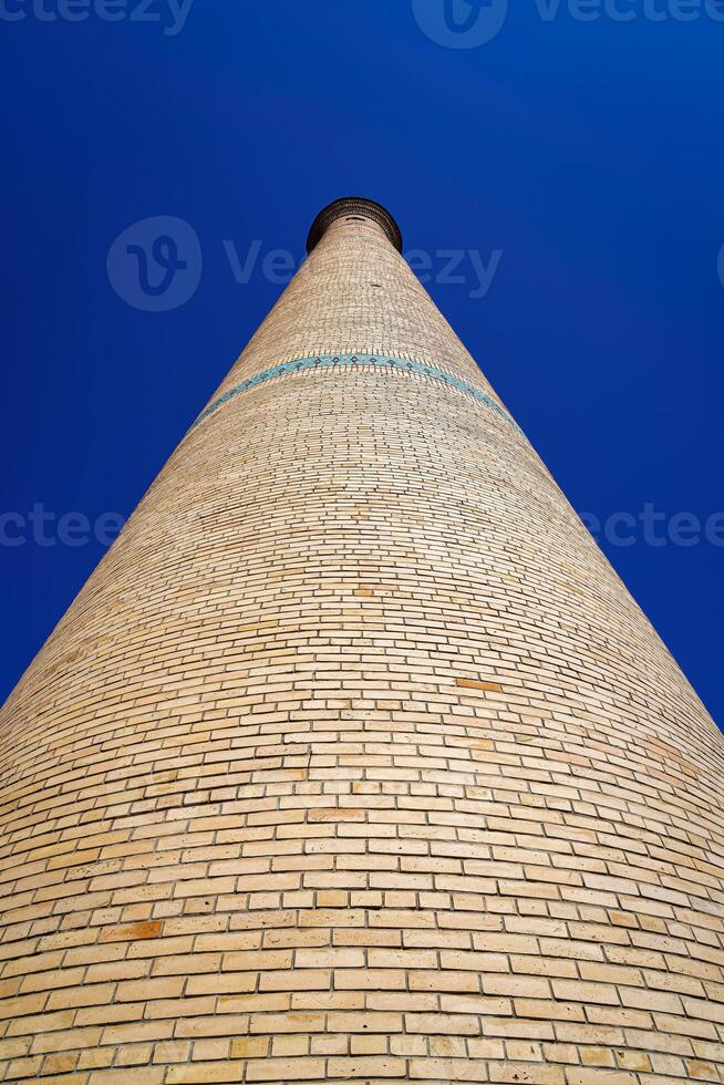 il minareto di un' mattone moschea contro un' blu cielo. foto