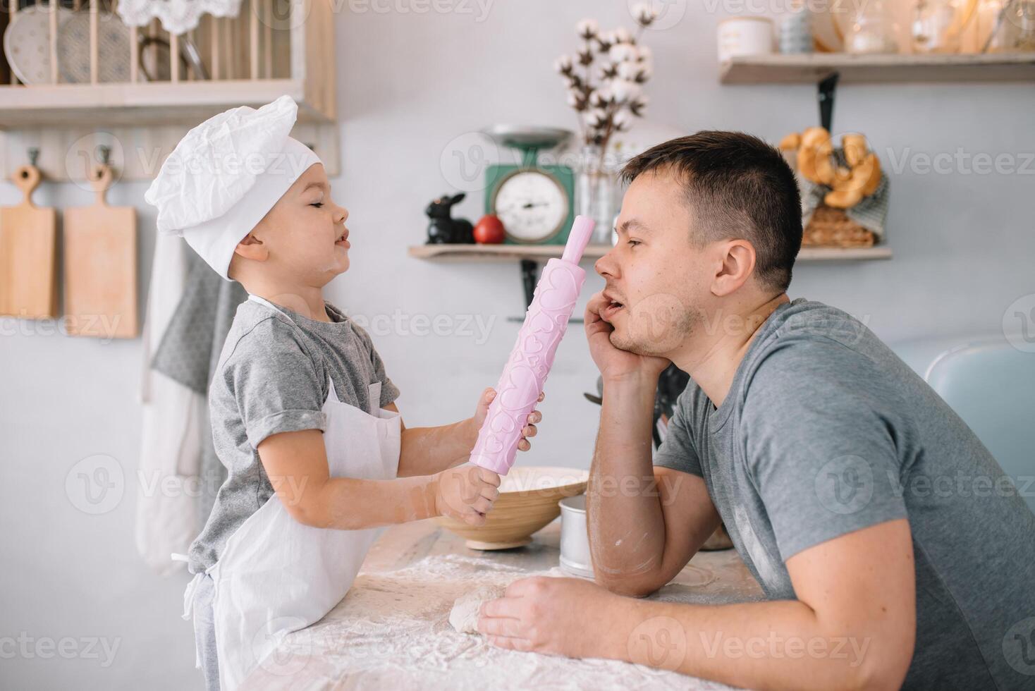 giovane uomo e il suo figlio con forno foglio nel cucina. padre con poco figlio su il cucina. foto