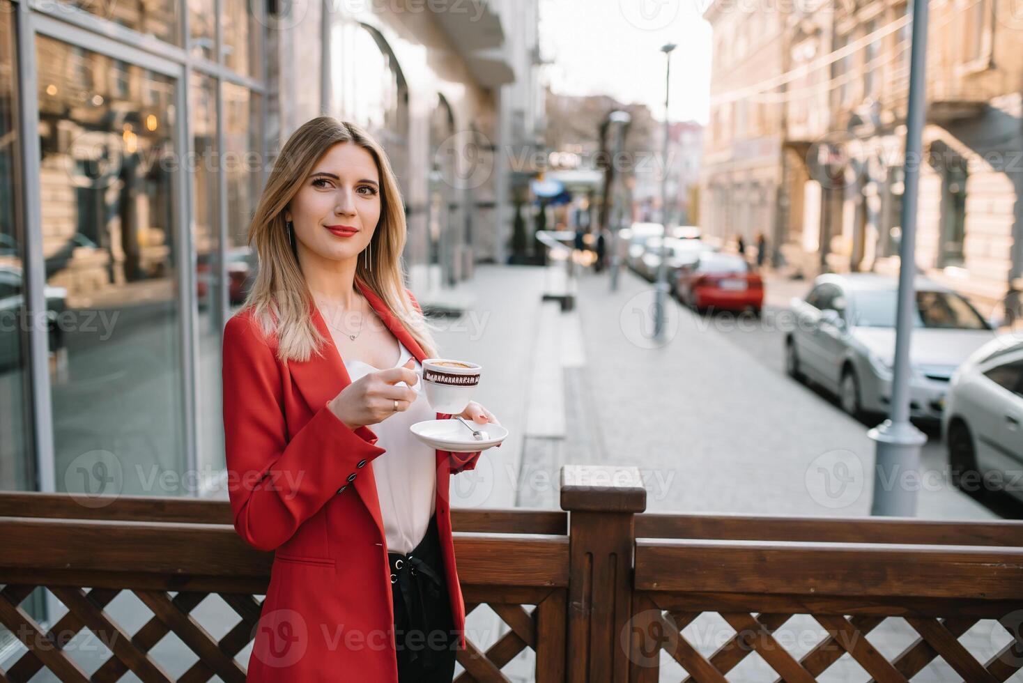 bellissimo giovane donna d'affari con un' monouso caffè tazza, potabile caffè, e Tenere tavoletta nel sua mani contro urbano città sfondo foto