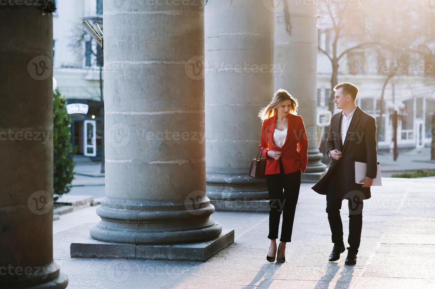 attività commerciale donna e attività commerciale uomo uso smartphone e parlare su il occupato grande città strada. tutti e due Guarda squisitamente elegante. foto