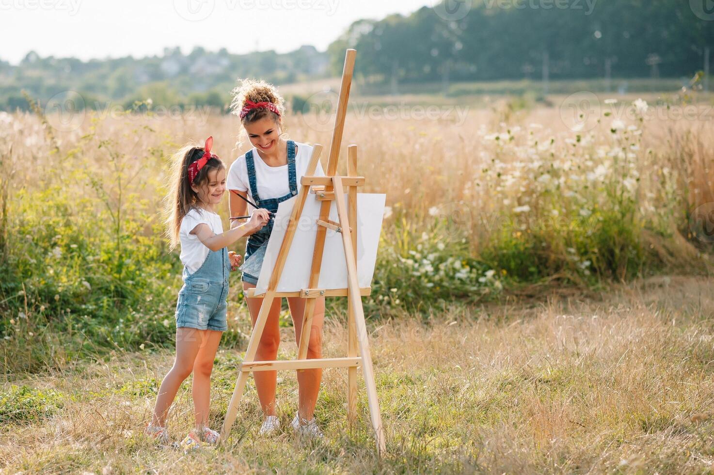 giovane madre e sua figlia avere divertimento, La madre di giorno. sorridente madre con bellissimo figlia disegna natura. foto