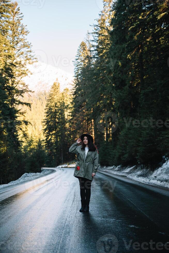 contento ragazza con cappello nel foresta a montagna strada sfondo, rilassare tempo su vacanza concetto viaggio ,colore di Vintage ▾ tono e morbido messa a fuoco foto