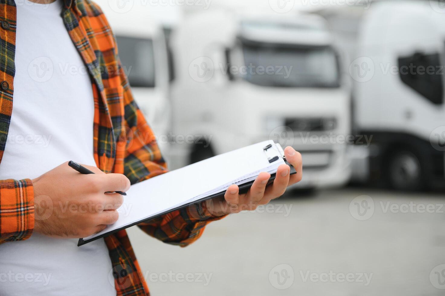 maschio autista con appunti vicino grande camion all'aperto foto