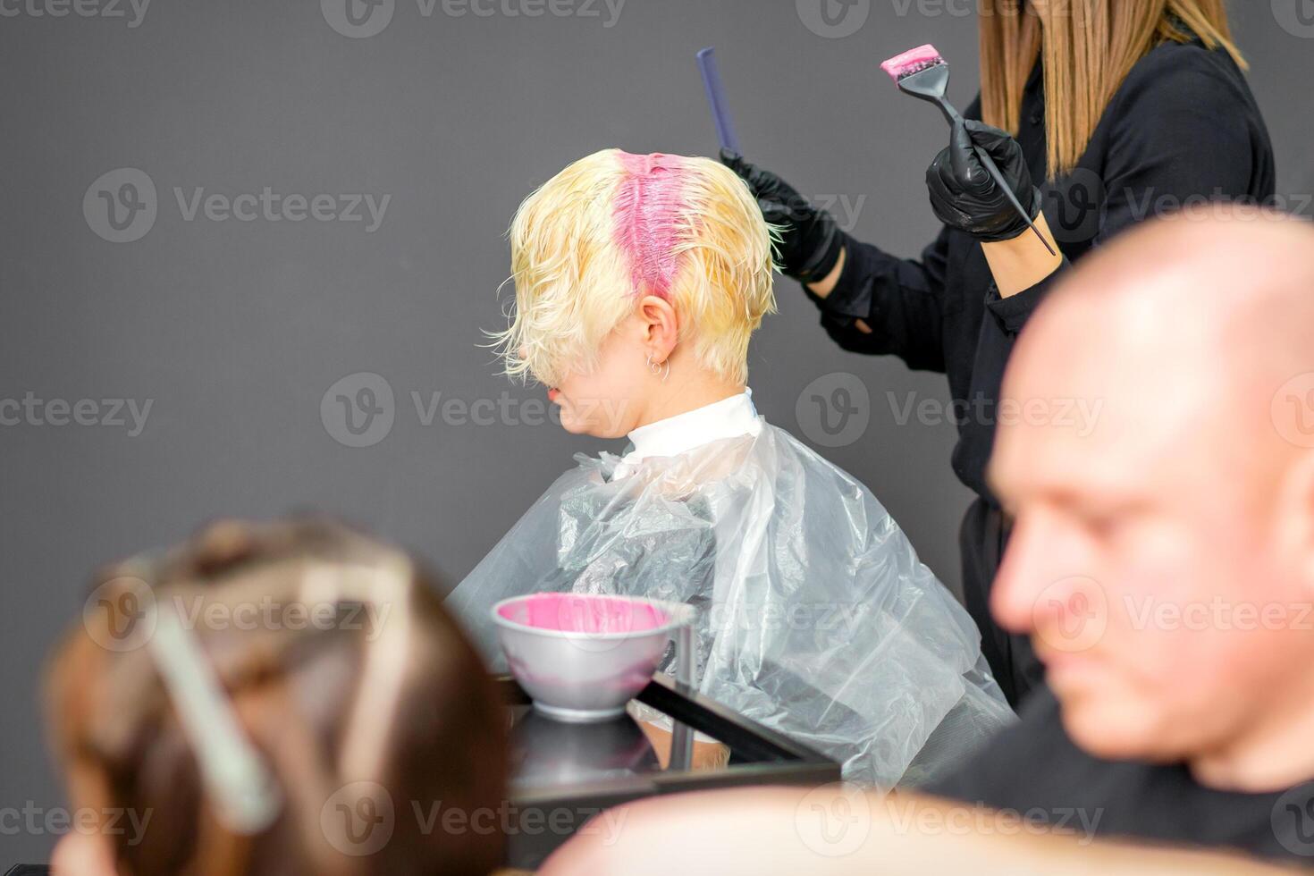 colorazione femmina capelli nel il capelli salone. giovane donna avendo sua capelli tinti di estetista a il bellezza salotto. foto
