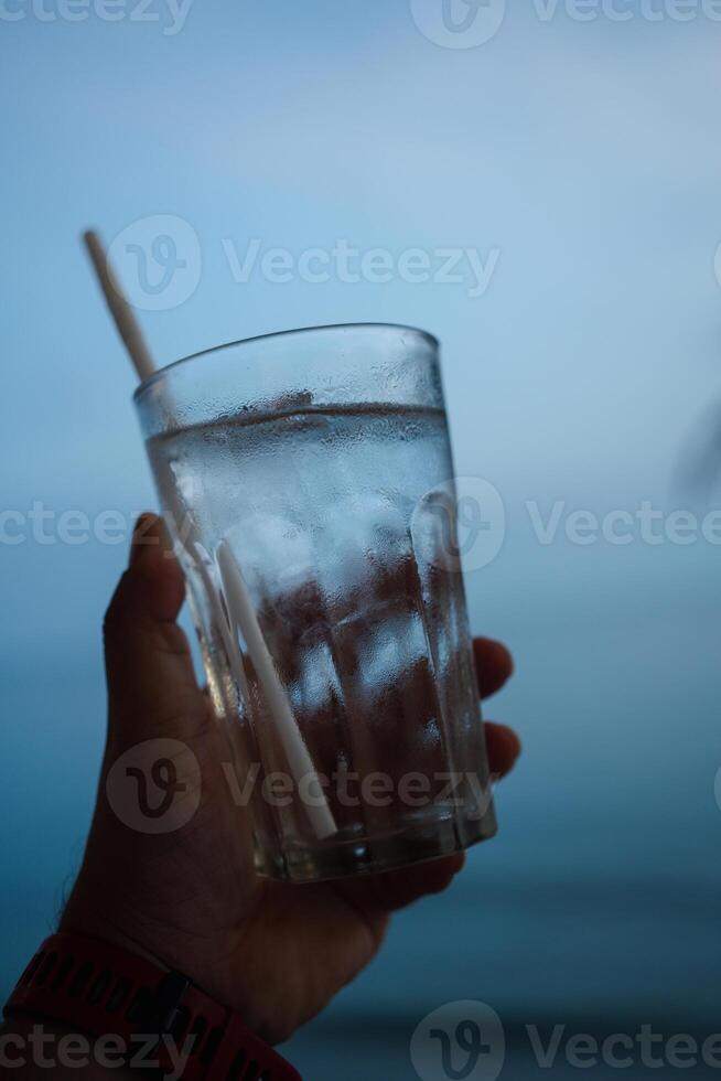 un' uomo Tenere un' bicchiere di acqua foto