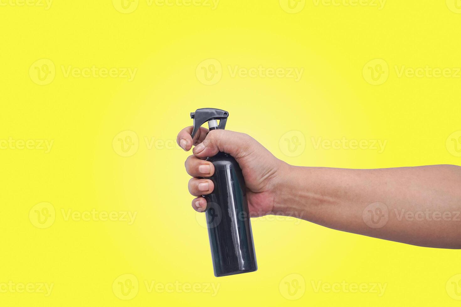 vicino su di mano hold un' spray bottiglia foto