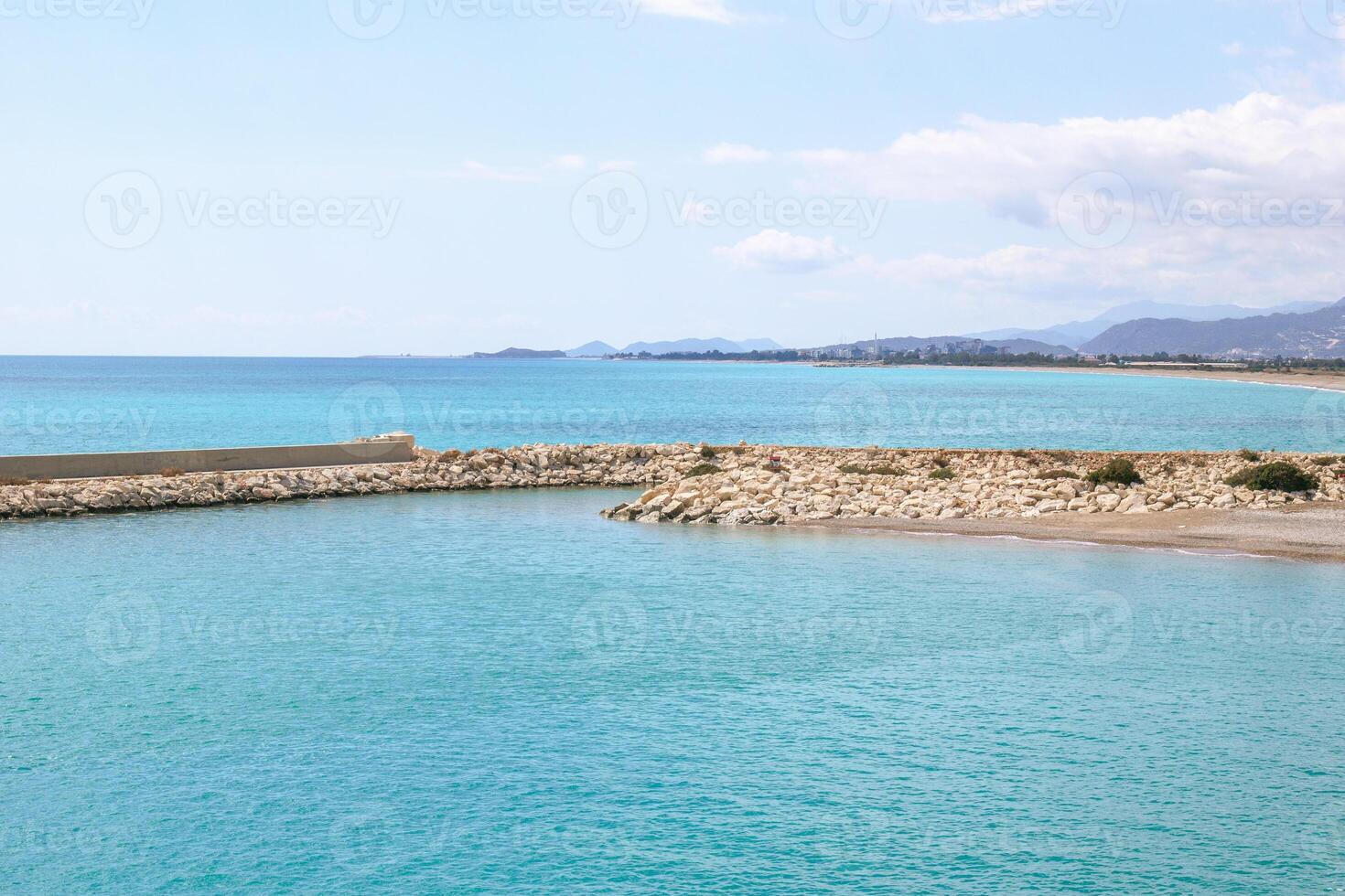 Visualizza su roccioso spiaggia con chiaro blu mare e frangiflutti a il soleggiato giorno. mediterraneo mare vicino per demre, tacchino. foto
