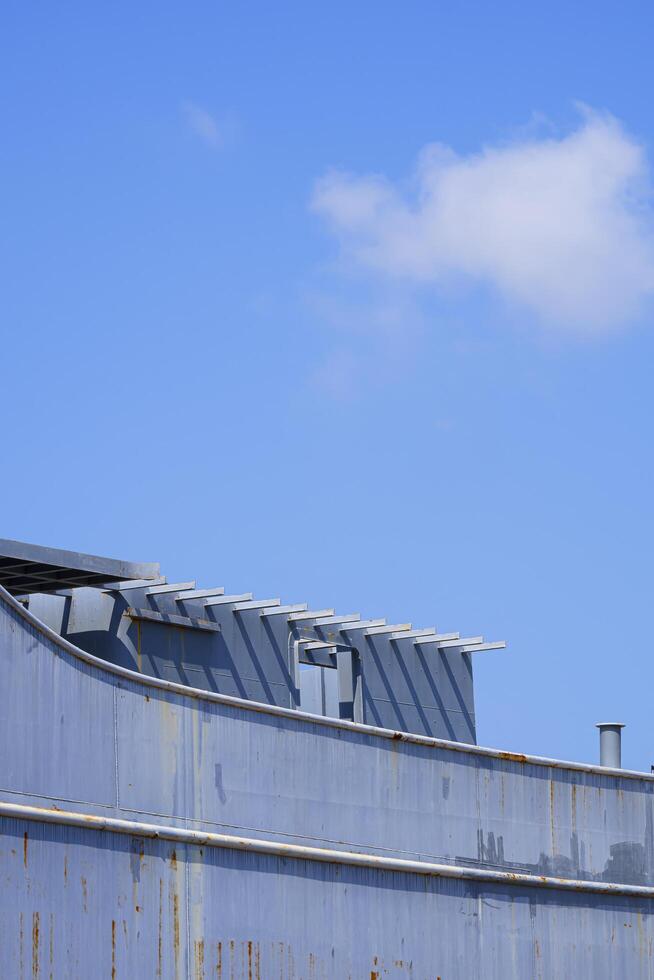 il vecchio grigio nautico nave durante Manutenzione a cantiere navale contro blu cielo nel verticale telaio foto