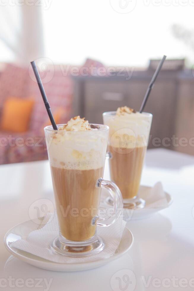 caffè è servito nel un' alto bicchiere bicchiere con un' cannuccia. il concetto di caffè bevande a partire dal il bar menù foto