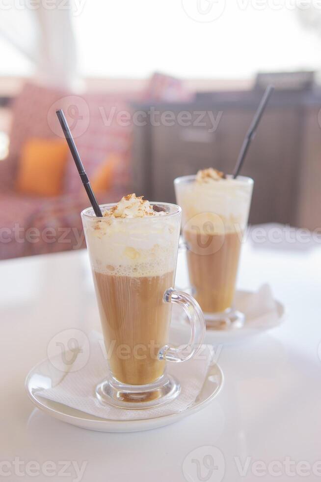 caffè è servito nel un' alto bicchiere bicchiere con un' cannuccia. il concetto di caffè bevande a partire dal il bar menù foto