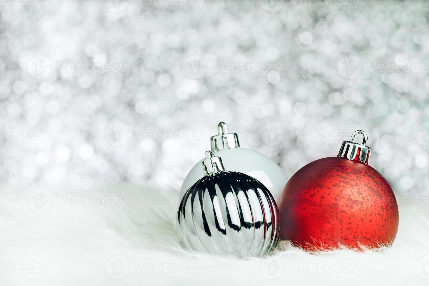 palla di decorazioni natalizie su pelliccia bianca a luce argento bokeh foto