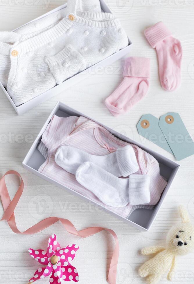 scatola con bambino cose e Accessori per neonato su bianca di legno sfondo. foto