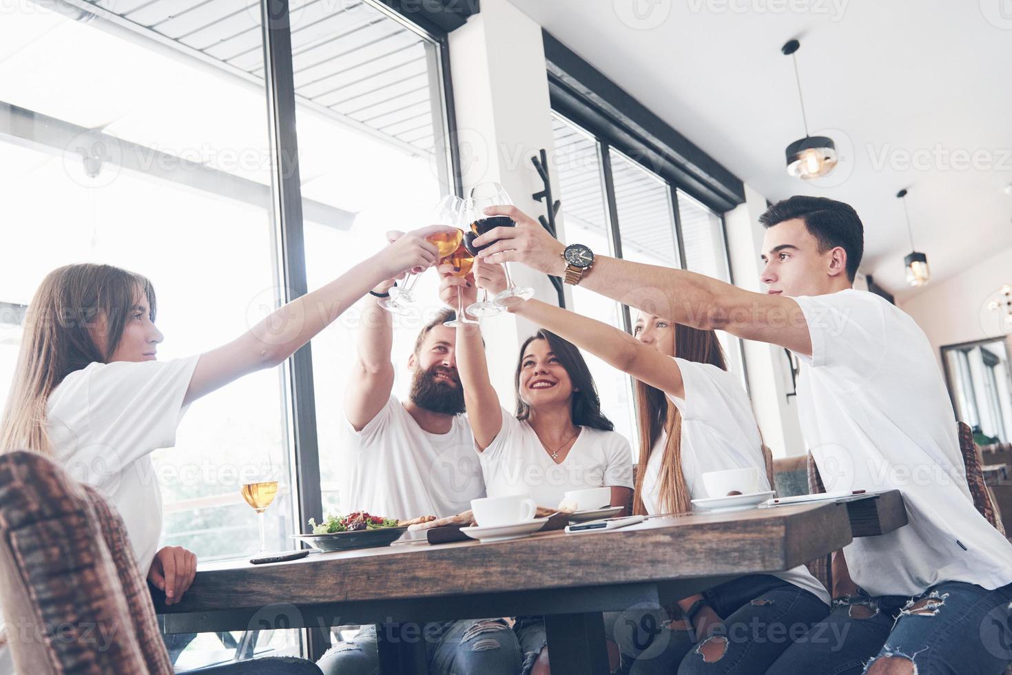 amici si sono riuniti a tavola con cibo delizioso con bicchieri di vino rosso per festeggiare un'occasione speciale foto