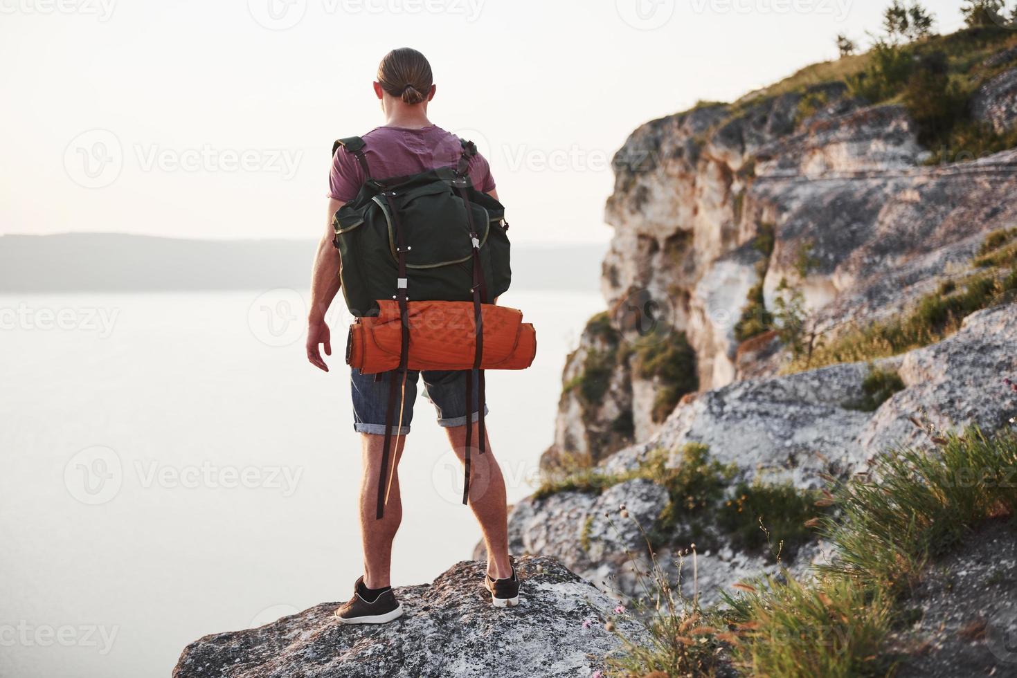 uomo attraente che gode della vista del paesaggio delle montagne sopra la superficie dell'acqua. concetto di vacanze avventura stile di vita di viaggio foto