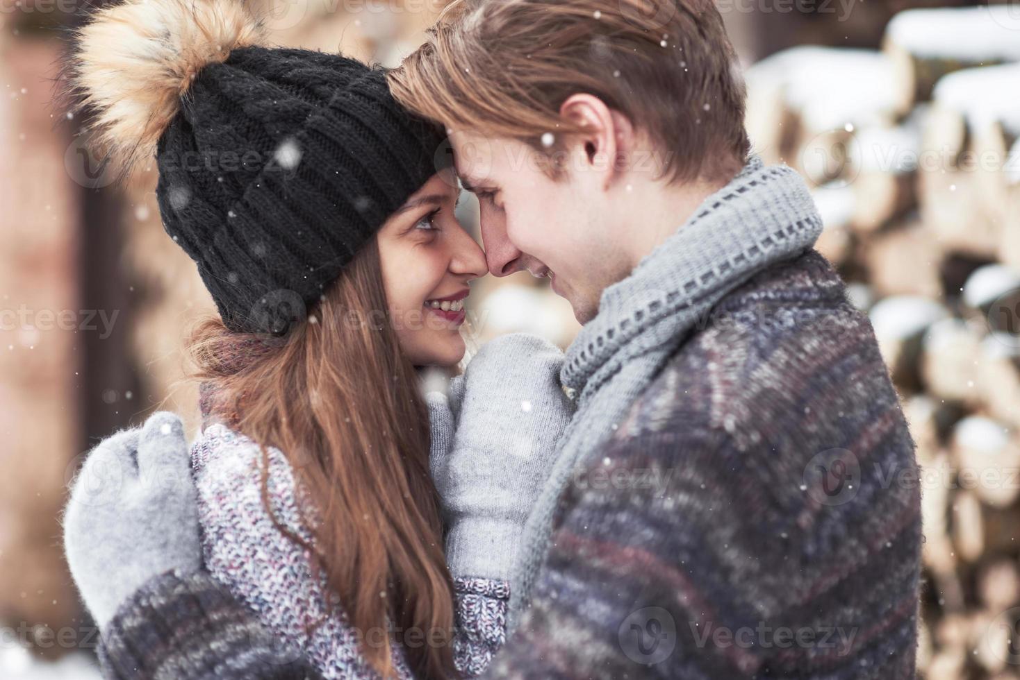 la coppia si diverte e ride. bacio. giovane coppia hipster che si abbracciano a winter park. storia d'amore invernale, una bella coppia giovane ed elegante. concetto di moda invernale con fidanzato e fidanzata foto