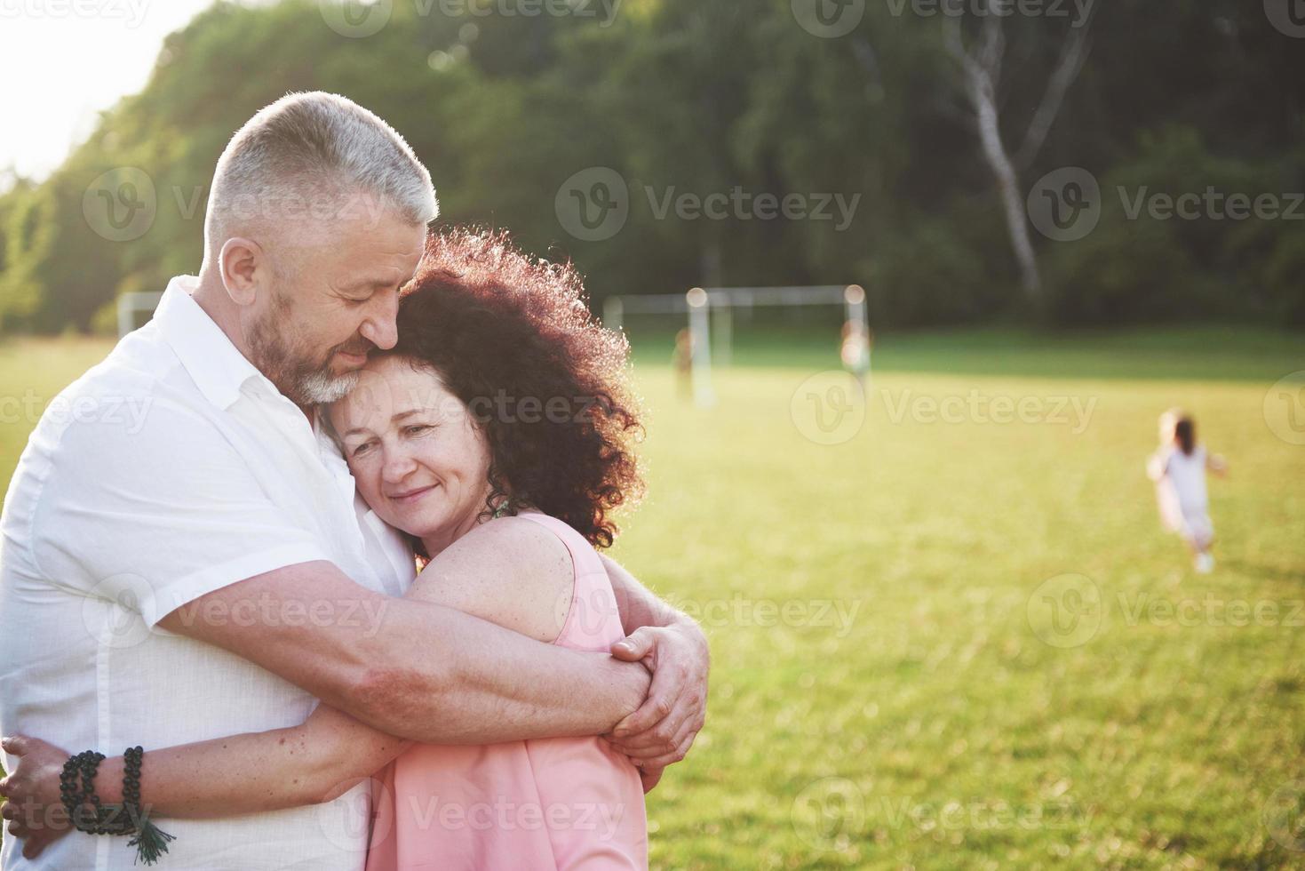 felice vecchia coppia estiva sorridente al parco in una giornata di sole. foto