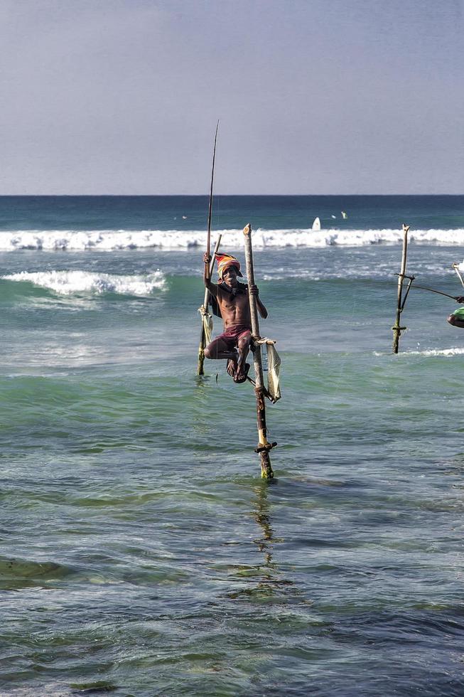 unawatuna, sri lanka, 25 gennaio 2014 - pescatori su trampoli non identificati a unawatuna, sri lanka. La pesca su trampoli è speciale per il distretto di Galle e ci sono circa 500 famiglie di pescatori nella fascia costiera. foto