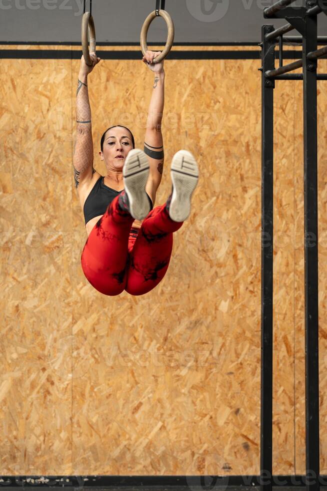 donna fare nucleo esercizi utilizzando olimpico squillare nel un' Palestra foto