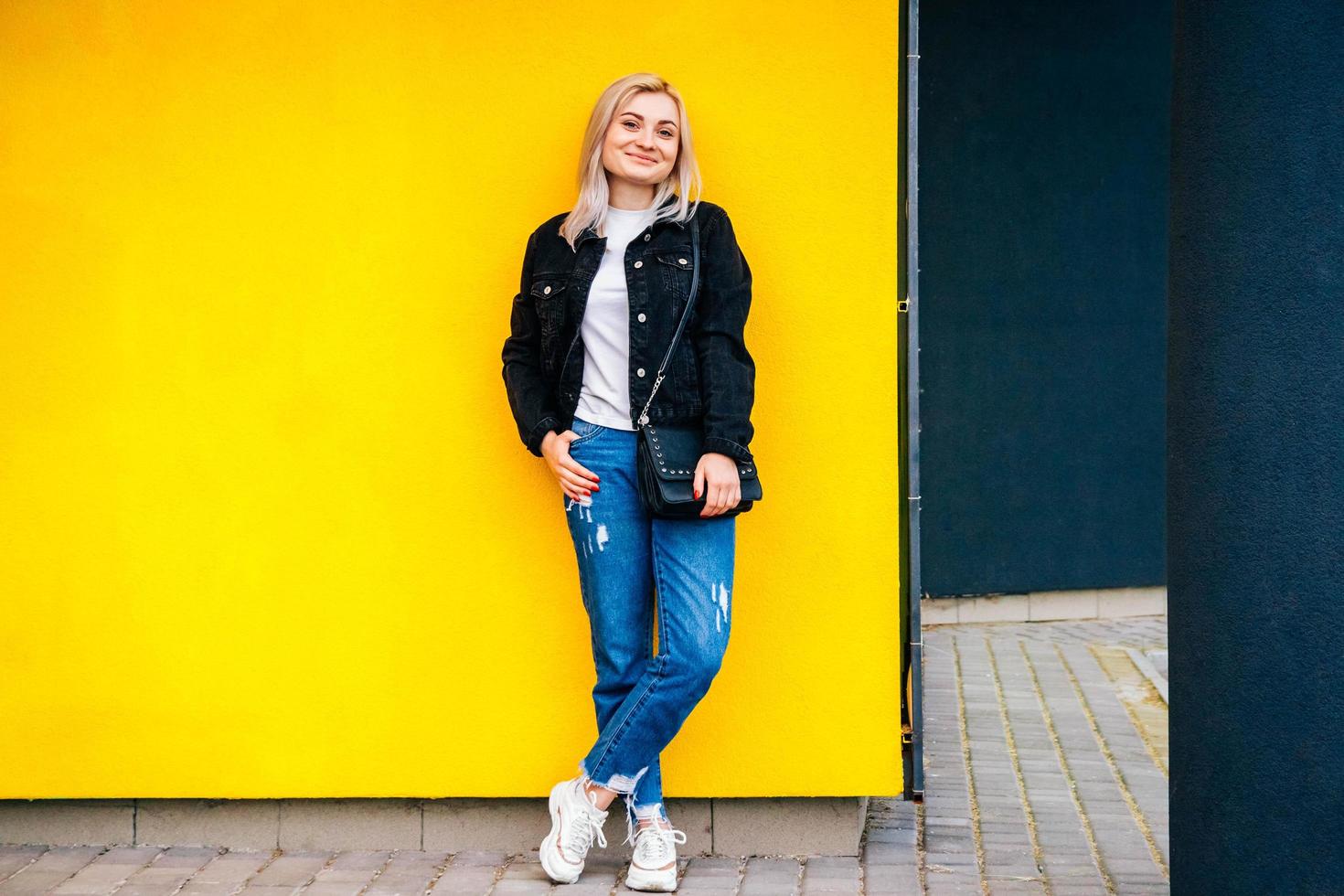 donna in posa su uno sfondo di muro giallo foto