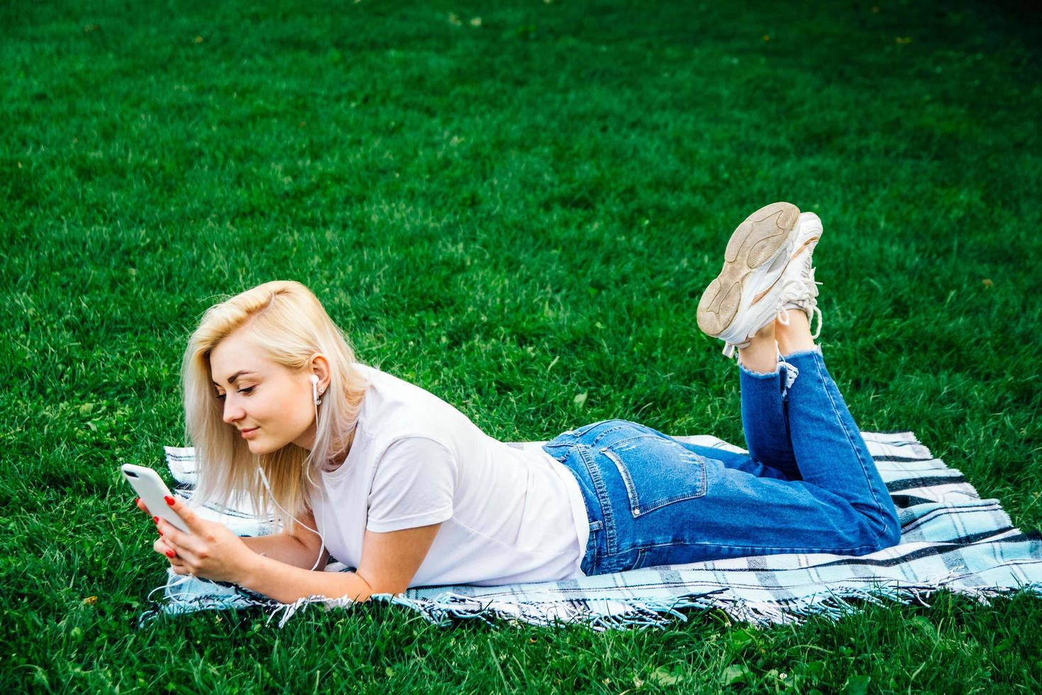 la donna in cuffia e smartphone in mano ascolta musica foto