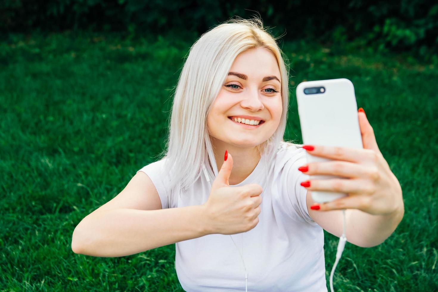 donna in cuffia e smartphone in mano foto
